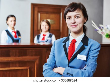 Happy Young Female Hotel Receptionist Worker Standing At Reception