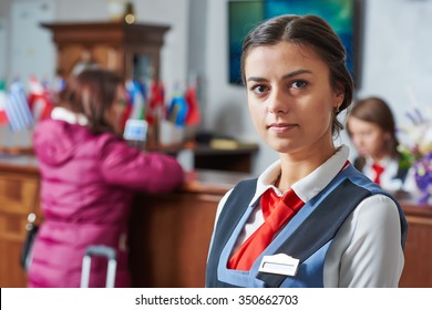 Happy Young Female Hotel Receptionist Worker Standing At Reception