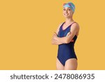 Happy young female swimmer on yellow background