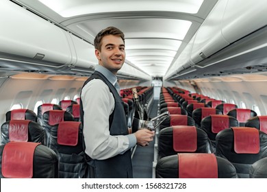 Happy young flight attendant with champagne for passengers - Shutterstock ID 1568321728