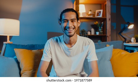 Happy young freelance asian man looking at camera smile and talk with friends on video call online at night in living room at home, Stay at home quarantine, work from home, Social distancing concept. - Powered by Shutterstock