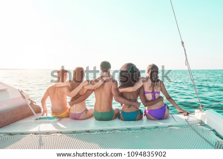 Happy young friends chilling in catamaran boat - Relaxed people making ocean caribbean tour - Travel lifestyle, summer, friendship, tropical concept - Focus on bodies