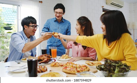 Happy Young Friends Group Having Lunch At Home. Asia Family Party Eating Pizza Food And Laughing Enjoying Meal While Sitting At Dining Table Together At House. Celebration Holiday And Togetherness.