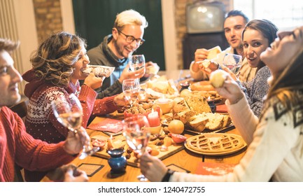 Happy Young Friends Group Tasting Christmas Sweet Food Having Fun At Home Wine Party - Winter Friendship Concept With Millenial People Enjoying New Year's Eve Supper Eating Together - Warm Filter