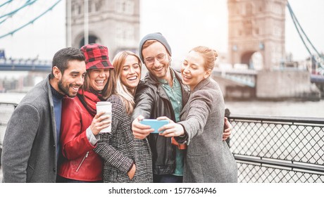 Happy young friends making videos for social media network next Tower bridge - Millennial people having fun with new trends technology - Travel and friendship concept - Main focus on right man face