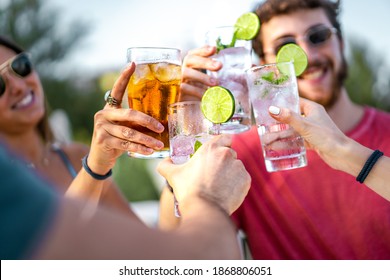 Happy young friends toasting with mojito cocktails together. Focus on the glasses clinking. Friendship and alcohol abuse concept. - Shutterstock ID 1868806051