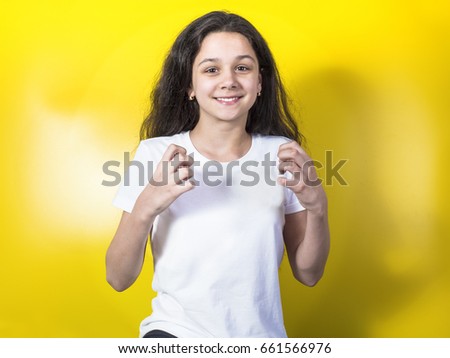 Happy young funny woman. Isolated over yellow background
