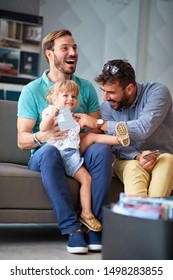 Happy Young Gay Couple Enjoying In Shopping And Having Fun With Their Little Girl