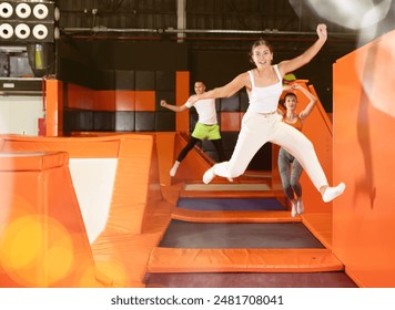 Happy young girl doing jumping at the trampoline center - Powered by Shutterstock