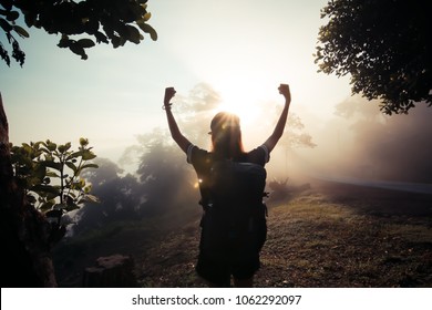 Happy Young Girl Enjoy Backpacking.Watch The First Light Of The Morning Sun On The Mountain.Feel Refreshed And Energize Your Life.