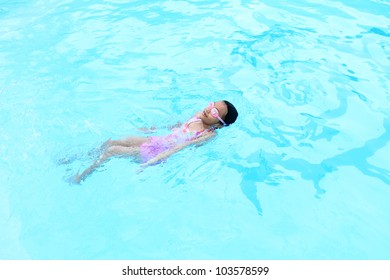 Happy young girl having fun in the swimming-pool