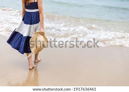 Happy young girl hold hat and walking on the beach. Summer travel, vocation, holiday concept.