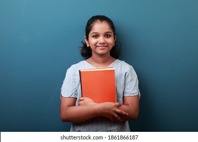 Happy young girl holding note books in her hand
