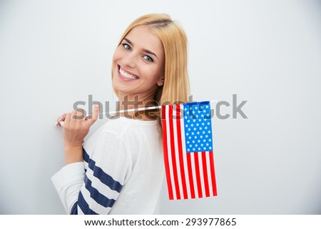 Happy young girl holding USA flag over gray background