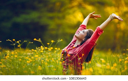 Happy young girl smiling with arms raised outdoor. Freedom and praying concept. 