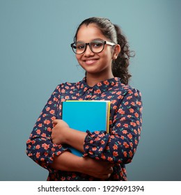 Happy young girl with spectacles holding note books in her hand