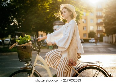 Happy young girl in summer clothes riding bicycle at the city street outdoor. Tourist woman using bicycle - Powered by Shutterstock