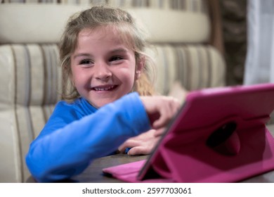 Happy young girl using a pink tablet, enjoying technology and online learning