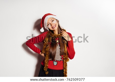happy young girl waiting for new year and christmas, wants gifts, wearing red festive sweater, smiling