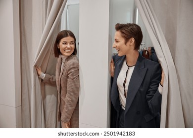 Happy young girlfriends in fitting room in clothing department store - Powered by Shutterstock