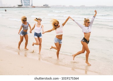 Happy young girls having a good time on the beach by the sea. 