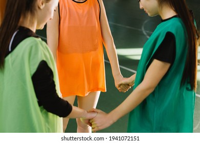 Happy young girls talking in sport gym before training. Female basketball players standing in court. Cropped photo of coach advising female players while practicing indoor game - Powered by Shutterstock