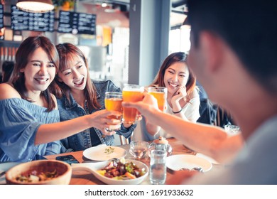 Happy Young Group Dining And Drinking Beer At Restaurant