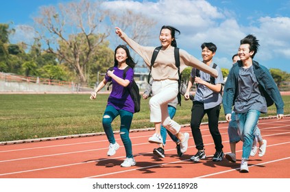 Happy young group students running Across Field