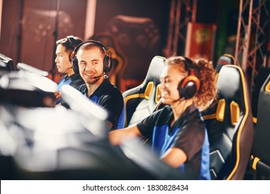 Happy Young Guy, Male Gamer Wearing Headphones Looking Mixed Race Girl Sitting Close To Him, Cybersport Team Participating In ESport Tournament