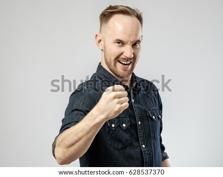 Happy young handsome man gesturing isolated on gray background