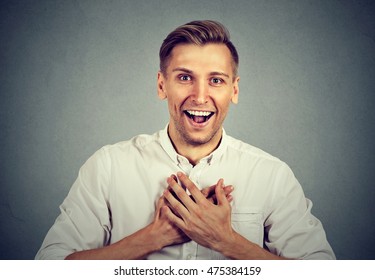 Happy Young Handsome Man Looking Shocked Surprised Laughing Hands On Chest Open Mouth, Isolated On Gray Background. Positive Human Emotion Facial Expression Feeling