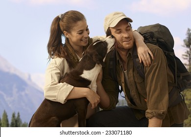 Happy Young Hiking Couple With Dog Outdoors.