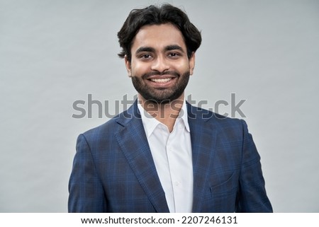 Happy young indian business man ceo leader, arab professional manager, smiling expert businessman executive wearing suit looking at camera isolated on beige, close up headshot portrait.