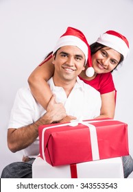 Happy And Young Indian Couple With Christmas Gifts, Over White Background