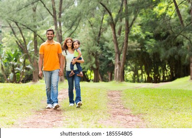 Happy Young Indian Family Going For A Walk In Forest