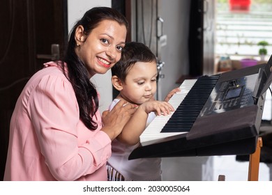 Happy Young Indian Female Music  Teacher Teaching Kid Electric Keyboard. Hobby Classes. 