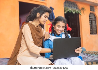 Happy Young Indian Girls Using Laptop. Two Sisters Or Friends Wearing School Uniform Holding Computer At Home, Female Education And Skill India Concept.