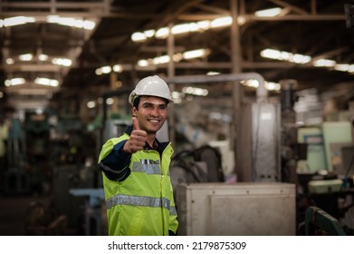 Happy Young Indian male engineer wearing safety workwear standing in the factory and thumbs up to appreciate the success of the teamwork. safety first in the industrial plant. - Shutterstock ID 2179875309