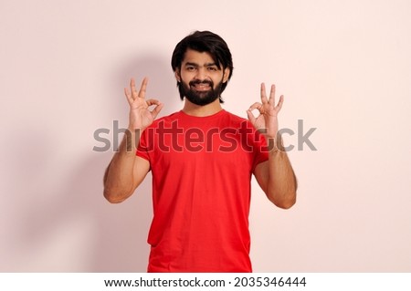 Happy young Indian man showing ok sign with both hands, gesturing and smiling, everything is going to be okay 