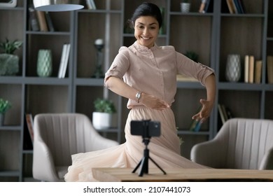 Happy Young Indian Woman Recording Ballet Dance Moves On Cellphone Web Camera, Doing Rehearsal Or Streaming Live Video In Social Network At Home, Sharing Professional Skills Online.