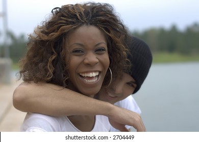 Happy young interracial couple looking into camera