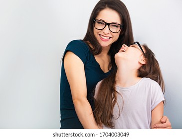 Happy Young Joyful Casual Mother And Smiling Kid In Fashion Glasses Hugging On Light Blue Background With Empty Copy Space. Closeup Studio Portrait