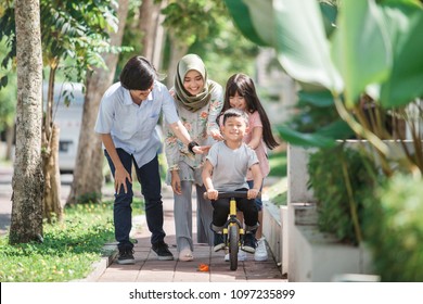 Happy Young Kid Having Fun With Sister Riding A Bike