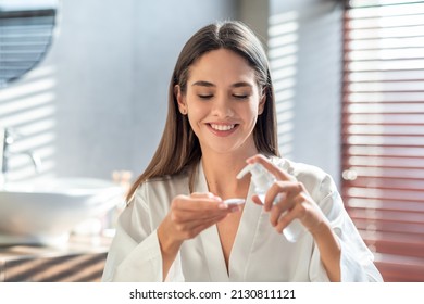 Happy young lady applying hydrophilic oil on cotton pad for cleansing face, smiling beautiful woman making daily skincare routine in bathroom, enjoying making beauty treatments at home, free space - Shutterstock ID 2130811121