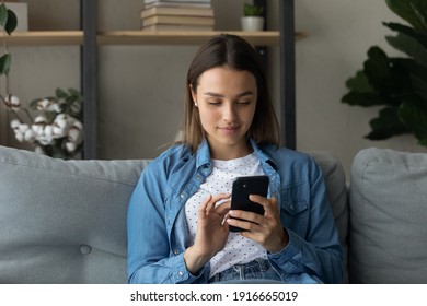 Happy young lady confident user of mobile phone applications discuss news with friends at social network check bank account make purchase at web shop. Relaxed teen female enjoy using modern smartphone