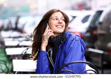 Happy young lady talking on mobile phone