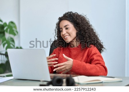 Happy young latin business woman employee, hr manager having remote videocall work hybrid meeting or job interview talking to team or partner looking at laptop on virtual video digital call in office.