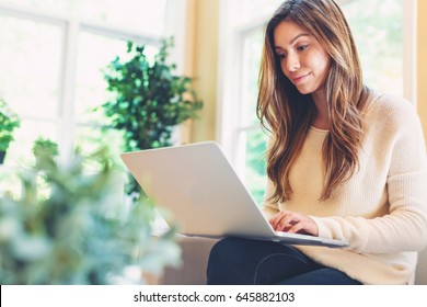 Happy Young Latina Woman Working On Her Laptop At Home