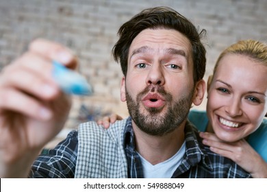 Happy Young Loving Couple Feeding Baby By Spoon. Photographed From Baby's Point Of View.