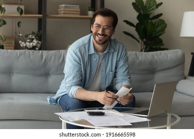 Happy Young Male Distracted Of Studying Terms Conditions Of Credit Documents Look Aside Plan Loan Mortgage Payments Count On Paper. Smiling Man Enterpreneur Find Legal Way To Cut Costs Get Tax Refund